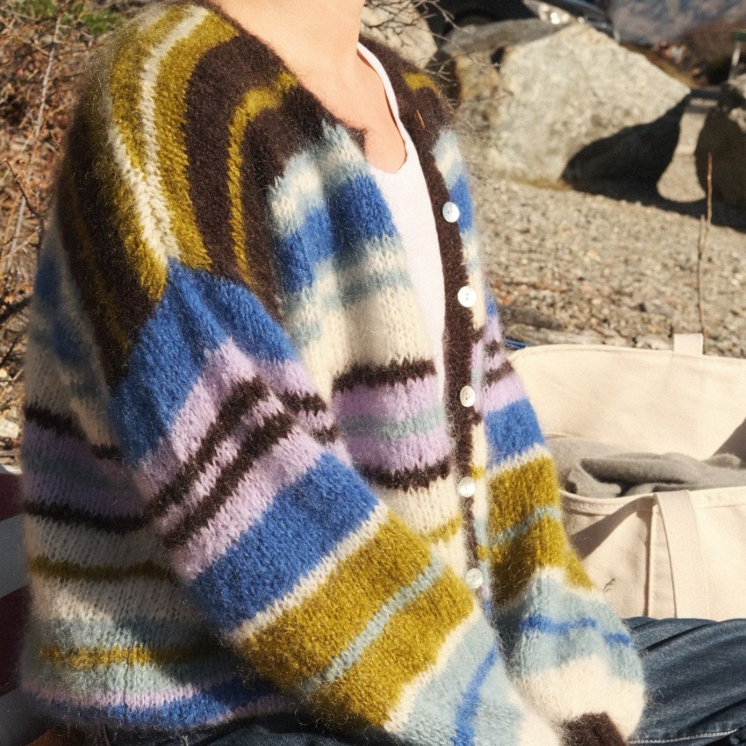 Person wearing a colorful striped sweater outdoors