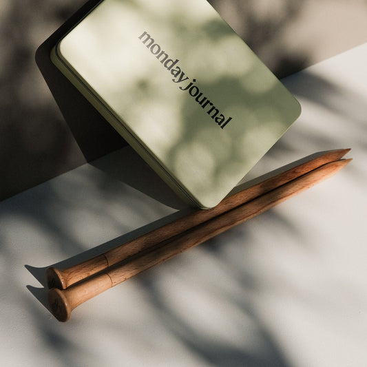 Beige rectangular box with 'monday journal' text on a gray background
