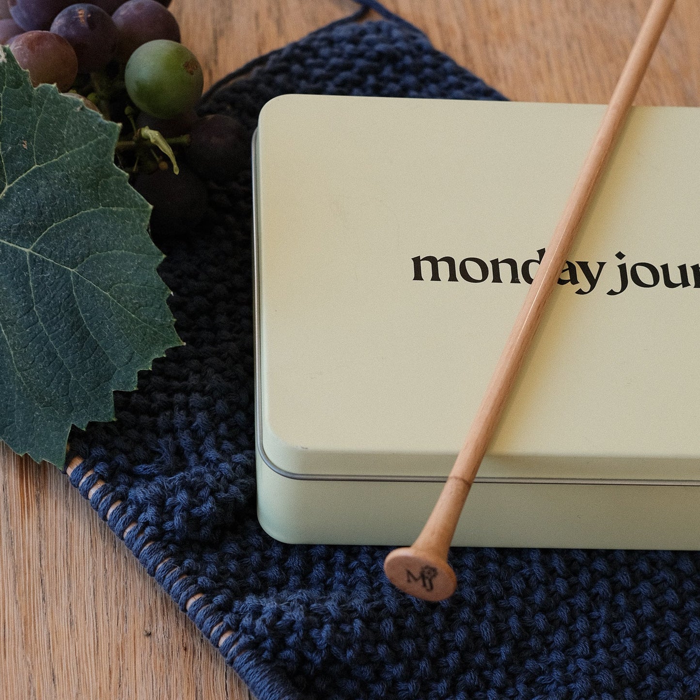 Light beige tin box with 'monday journey' branding on knititng