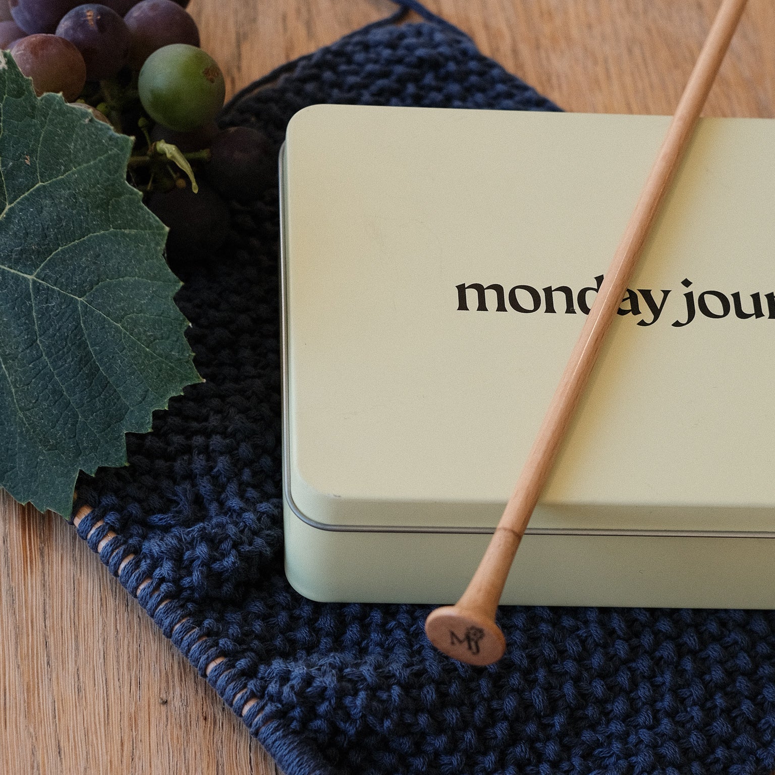Light beige tin box with 'monday journey' branding on knititng